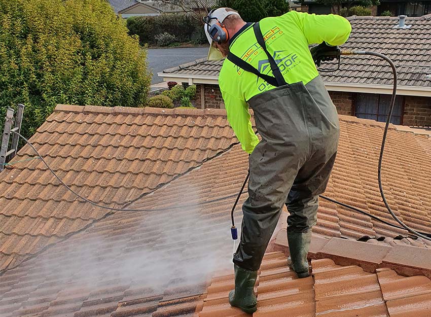 man on roof terracotta restoration