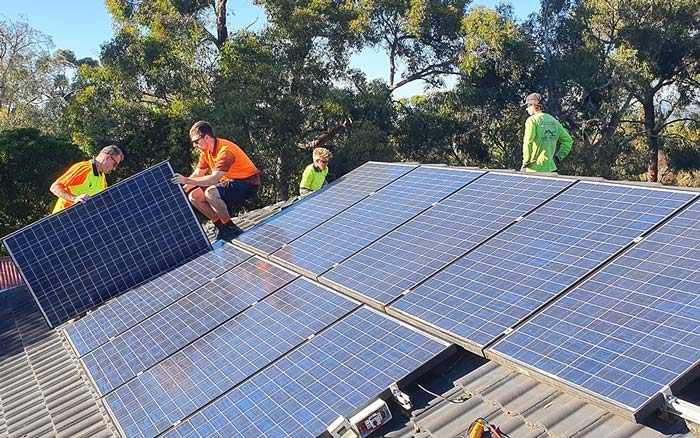 trades people removing solar panels from roof